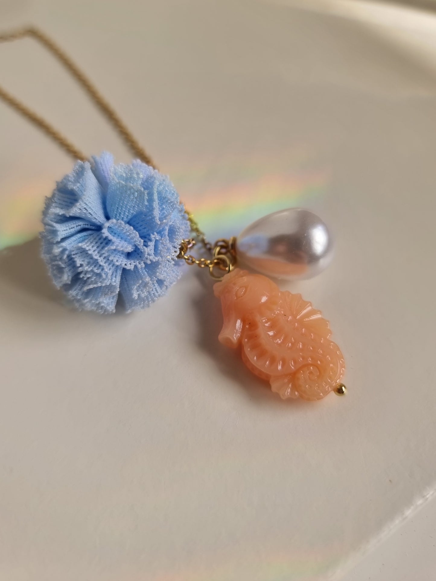 Meri! Seahorse charm necklace in peach with blue pompom